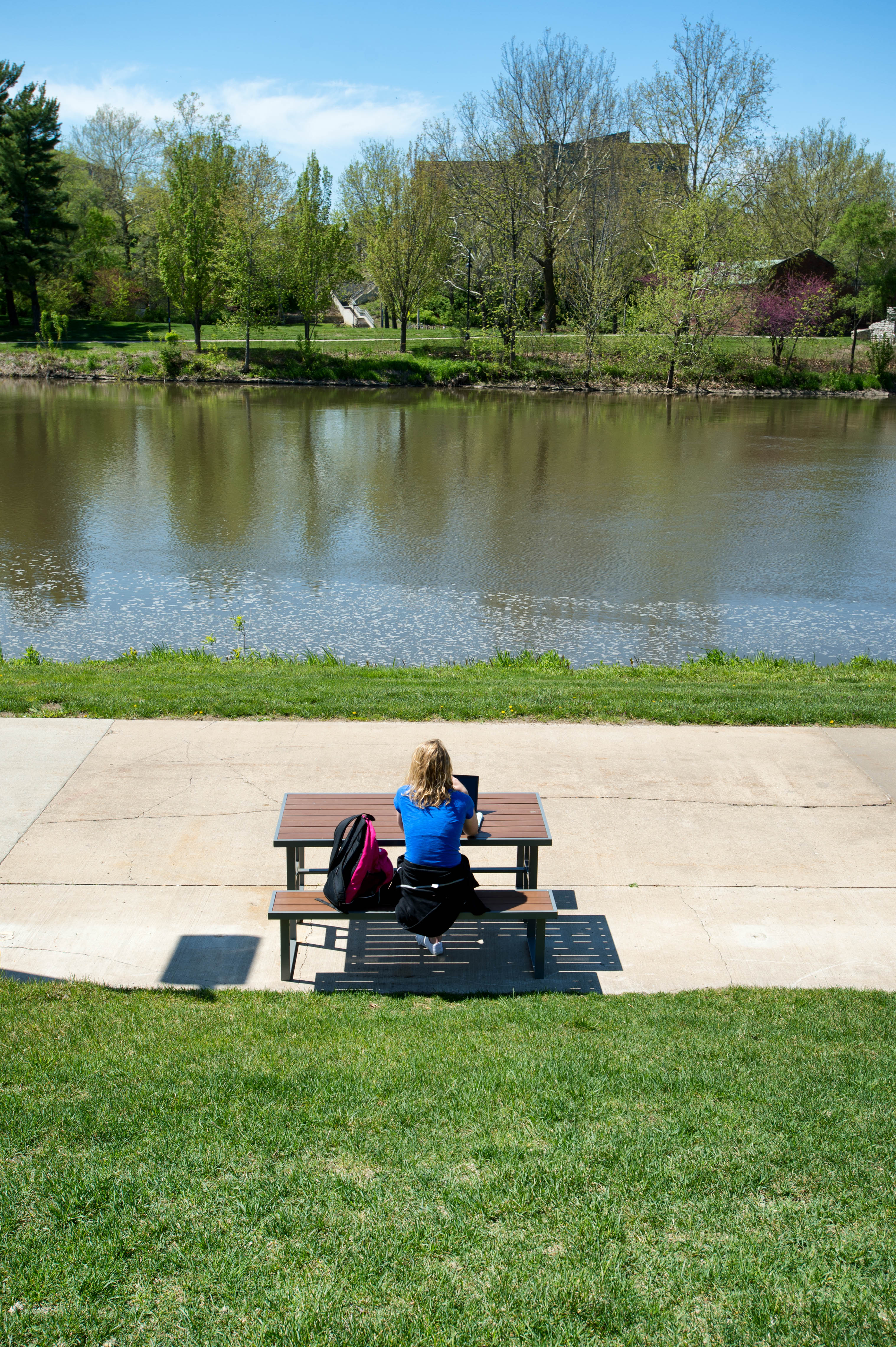 Student on Bench by River Behind Iowa Memorial Union